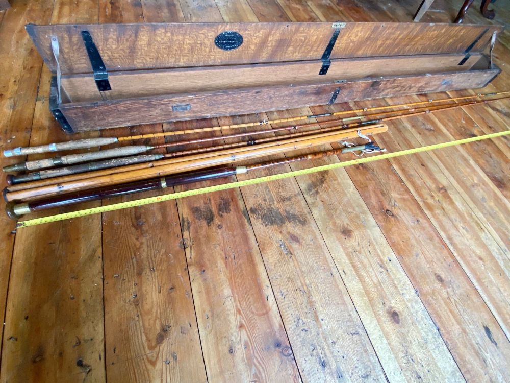 A Hardy oak and iron bound case containing three Hardys split cane fishing rods